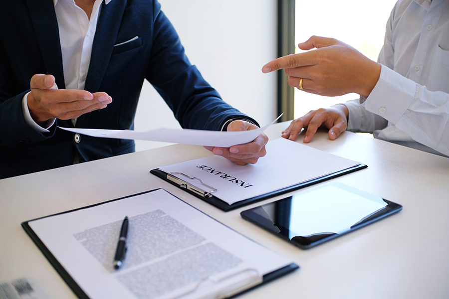 client pointing at insurance policy to agent holding the paper collegedale tn